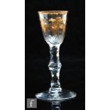 An 18th Century wine glass circa 1760, the round funnel bowl gilt decorated with a fruiting vine