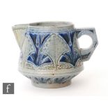 A small late 19th to early 20th Century Martin Brothers cream jug decorated with repeat incised