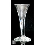 An 18th Century drinking glass circa 1740, the trumpet bowl above a plain teared stem, raised to a