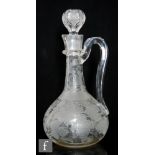 A late 19th Century crystal glass claret jug of compressed globe and shaft form with high loop