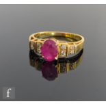 An 18ct ruby and diamond ring, central claw set oval ruby flanked by twin pairs of diamonds to