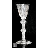 An 18th Century drinking glass circa 1750, the round funnel bowl engraved with a head and