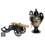 A 20th Century brass and iron decorative model canon, length 45cm, and a twin handled glazed pottery