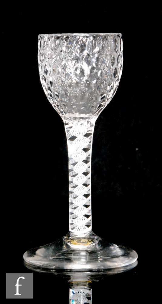 An 18th Century drinking glass circa 1765, the honeycomb moulded ogee bowl above a double series