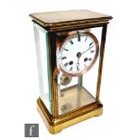 An early 20th Century brass mantle with suspended dial in bevelled glass case, on stepped base,