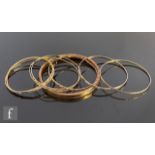 Seven assorted 9ct jingle bangles with a similar 9ct bangle, total weight 43g, S/D. (8)