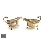 A pair of hallmarked silver sauce boats of plain form each raised on three pad feet, below gadroon