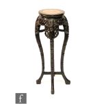 A late 19th and early 20th Century Chinese carved hardwood jardiniere stand with rouge marble