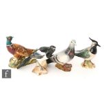 Four Beswick bird figures comprising a 2416 Lapwing, a 2305 Magpie, a 1383 Pigeon and a 1226