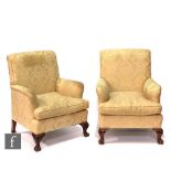 A pair of Edwardian style easy chairs on claw and ball feet, upholstered in cream floral damask. (2)