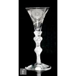 An 18th Century Jacobite drinking glass circa 1760, the trumpet bowl engraved with a six petalled