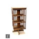 An Edwardian mahogany revolving bookcase, slatted sides over central block column, on plinth base,