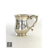 A hallmarked silver baluster half pint tankard of plain form, terminating in acanthus capped