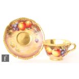 A later 20th Century matched Royal Worcester Fallen Fruits teacup and saucer, the saucer decorated