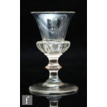 An 18th Century dram glass circa 1750, the trumpet form bowl with deep gadrooned base above a stem