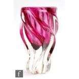 A later 20th Century Murano type vase of wrythen form in red cased in clear crystal, unmarked,
