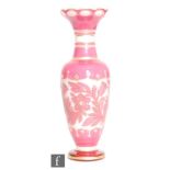A late 19th Century Bohemian glass vase of slender baluster form, circa 1880s, cased in pink over