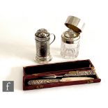 A hallmarked silver pepper pot of beaten cylindrical form with scroll handle, height 9cm, with a