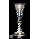 An 18th Century drinking glass circa 1720, the bell bowl above a pair of bead knops and an