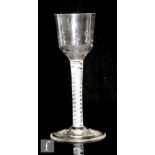 An 18th Century drinking glass circa 1765, the ogee bowl with basal hammered finish above a double