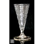 An 18th Century ale drinking glass circa 1740, the wrythen fluted bowl above a knopped stem,