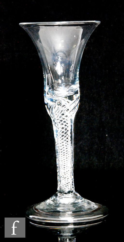 An 18th Century drinking glass circa 1740, the waisted bell bowl above a multi spiral air twist