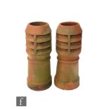 A pair of early 20th Century terracotta chimney pots of stepped circular form, height 77cm and