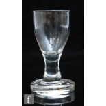 A late 18th Century dram glass circa 1800, the ovoid bowl over a plain waisted stem and raised to