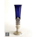 A hallmarked silver and blue glass sleeve vase, circular base rising to pierced neck and glass body,
