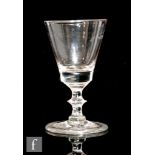 A late 18th Century drinking glass circa 1780, the bucket bowl above a bladed and basal knop stem,