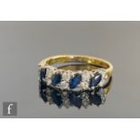 An 18ct sapphire and diamond ring, four marquise sapphires spaced by five pairs of claw set