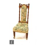 A Victorian high back turned walnut nursing chair, tapestry seat and back, on bobbin turned legs.