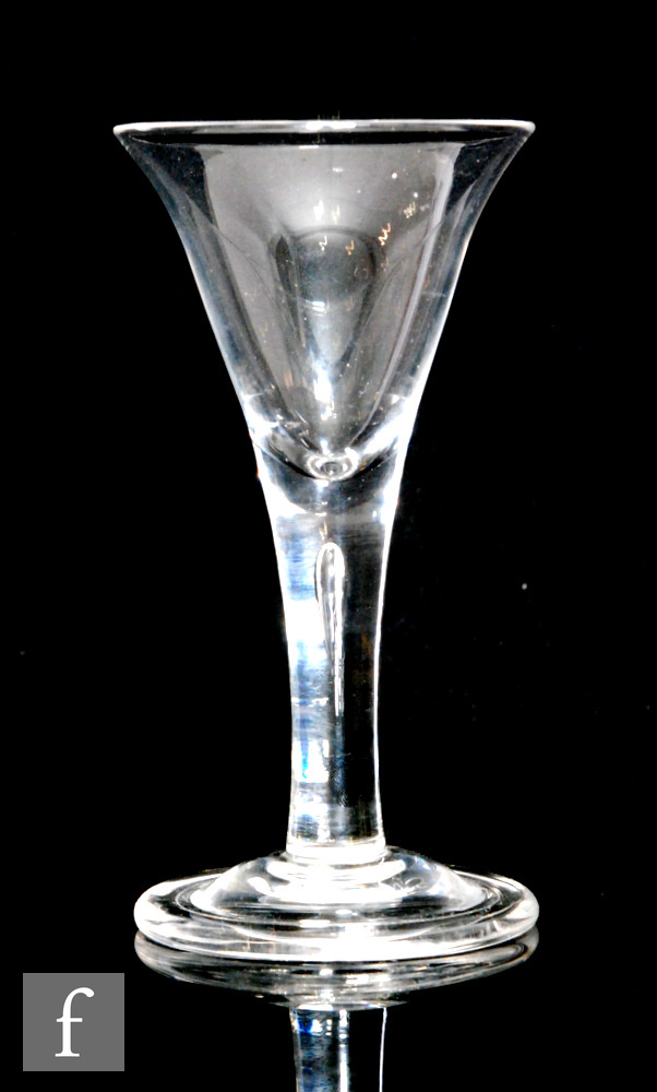 An 18th Century drinking glass circa 1740, the trumpet bowl above a plain tear drop stem, raised