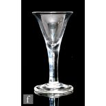 An 18th Century drinking glass circa 1740, the trumpet bowl above a plain tear drop stem, raised