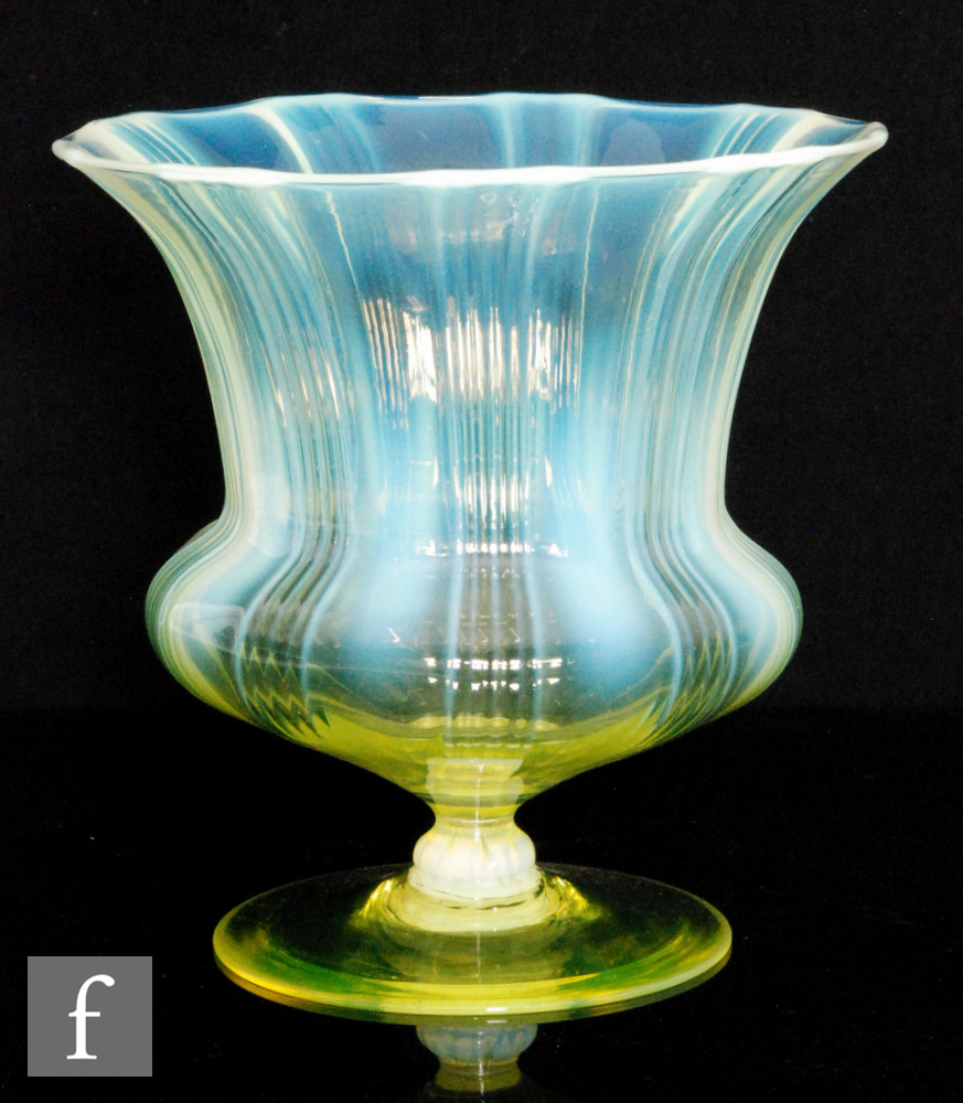 An early 20th Century John Walsh Walsh glass vase of waisted footed form, the ribbed bowl with