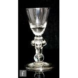 An 18th Century heavy baluster drinking glass circa 1710, the round funnel bowl