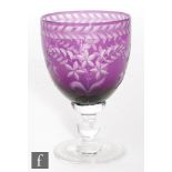 An early 20th Century Stourbridge crystal wine glass, the ovoid bowl cased in amethyst over clear