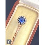 A late 19th Century sapphire and diamond stick pin, central cabochon sapphire within a border of