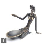 A bronze table salt by Richard Rohac formed as a kneeling African lady with her arms outstretched