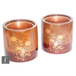A pair of Japanese hardwood and lacquered planters of cylindrical form, the claret coloured