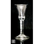 An 18th Century drinking glass circa 1740, the bell bowl above a plain stem, raised to a conical