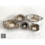 Five early 20th Century hallmarked silver embossed bon bon dishes, two with pierced decoration,