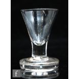 An 18th Century dram glass circa 1750, the trumpet form bowl above a short solid stem and raised