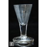 An 18th Century dram glass circa 1750, with conical bowl above a plain stem and raised to a heavy