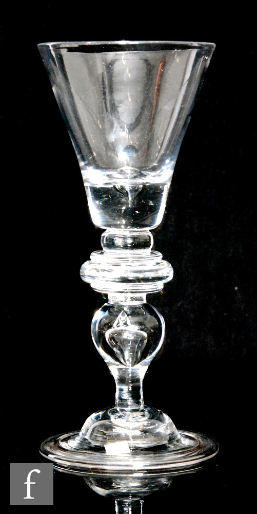 An 18th Century baluster drinking glass circa 1720, the trumpet bowl above three ringed annulated