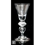 An 18th Century baluster drinking glass circa 1720, the trumpet bowl above three ringed annulated