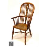 A 19th Century yew wood Windsor stick back elbow chair on turned baluster supports and legs united