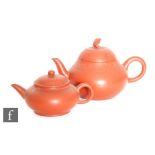 Two 20th Century Chinese red stoneware Yixing teapots, the first of pear form surmounted by a