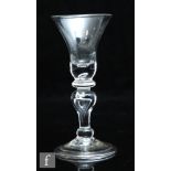 An 18th Century baluster wine glass, circa 1720, the bell bowl with solid base with tear over a stem