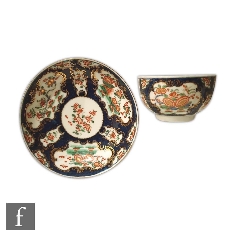 An 18th Century Worcester teabowl and saucer decorated with Kakiemon cartouche floral panels against
